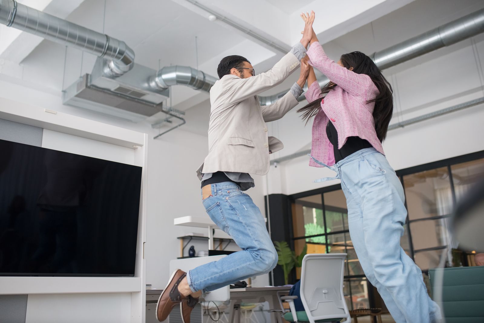 Colleagues celebrating with a high five in the office